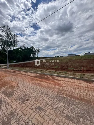 Vista da propriedade com estrada de terra no primeiro plano.