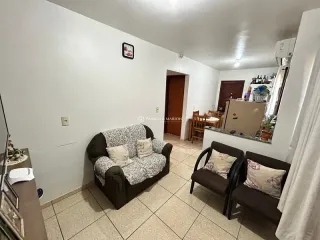 Sala de estar com sofá e piso de cerâmica clara.
