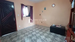 Uma sala de estar com piso de cerâmica e porta de madeira.
