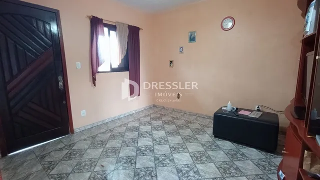 Uma sala de estar com piso de cerâmica e porta de madeira.