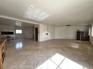 Uma sala ampla com piso de cerâmica e paredes brancas.