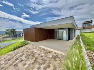 Fachada moderna de uma casa em Lajeado, Brasil, com revestimento em madeira e vidro.