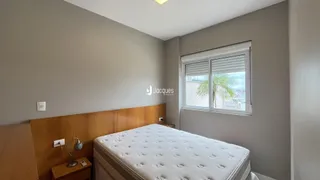 Quarto com cabeceira de madeira e janela.