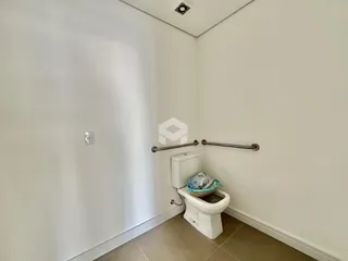 Foto de um banheiro com piso claro e acessórios de metal.
