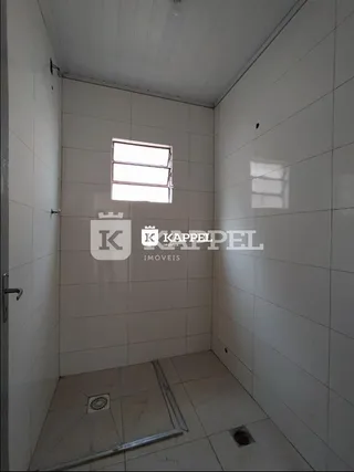 Foto interna de um banheiro com paredes brancas e piso claro.