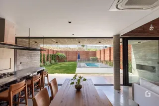 Vista de um ambiente moderno com acesso a um jardim e piscina ao ar livre.