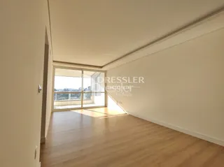 Hall de entrada com piso de madeira e janela no interior de uma residência.