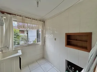 Interior de um cômodo com paredes brancas e piso de cerâmica.