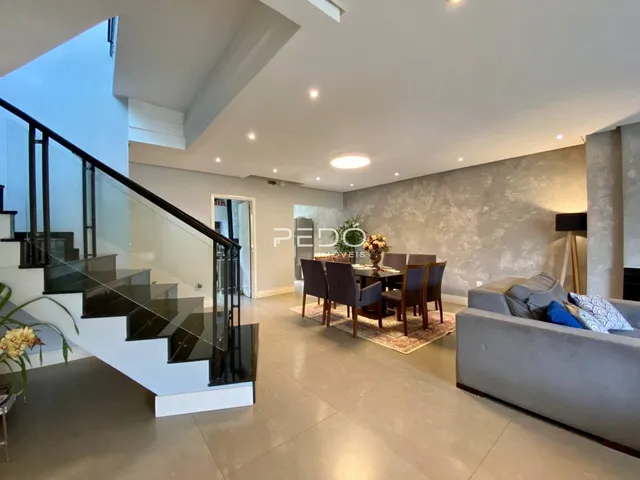 Sala de estar e jantar com escadaria em um apartamento moderno.