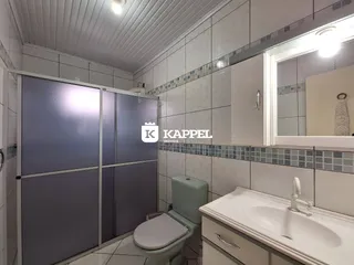 Foto de um banheiro com revestimento de azulejos brancos e bancada branca.