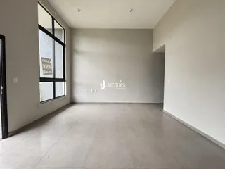 Uma sala com paredes brancas e piso de cerâmica.