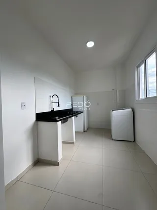 Interior de um cômodo com piso de cerâmica e bancada preta.