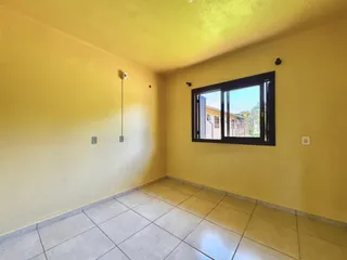 Esta é uma sala com paredes amarelas e piso de cerâmica.