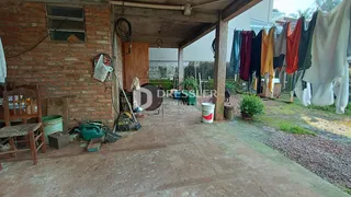Vista externa de um pátio com parede de tijolos e roupas secando ao ar livre.