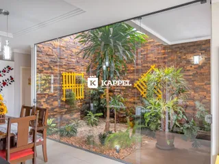 Sala de estar com parede de pedra e vegetação exuberante.