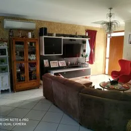 Foto de uma sala de estar com sofá e móveis de madeira.