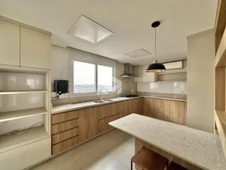 Cozinha moderna com armários de madeira e bancada clara.
