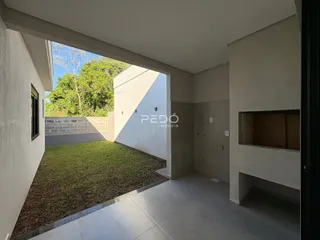 Vista interna de uma área que se abre para um jardim gramado.