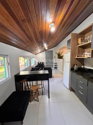 Sala de estar com piso de cerâmica e teto de madeira.