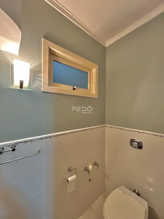 Foto de um banheiro com azulejos brancos e metais cromados.