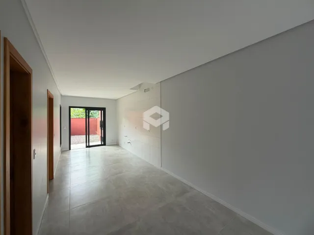 Hall de entrada com piso de cerâmica claro e paredes brancas.