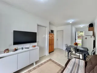 Sala de estar com televisão e área de jantar em um imóvel.