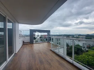 Vista de uma varanda com piso de madeira e vista da paisagem urbana.