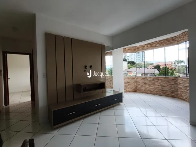 A sala de estar apresenta piso de cerâmica branca e paredes em tom neutro.