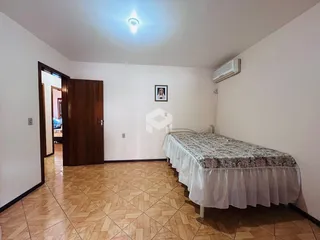 Quarto com cama e piso de cerâmica no imóvel.