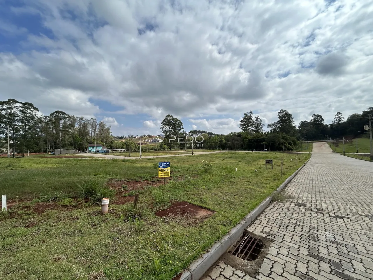 Vista externa de um terreno com gramado e caminho de terra em Lajeado.