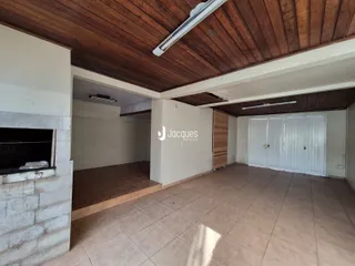 Interior de uma sala com teto de madeira e piso de cerâmica.