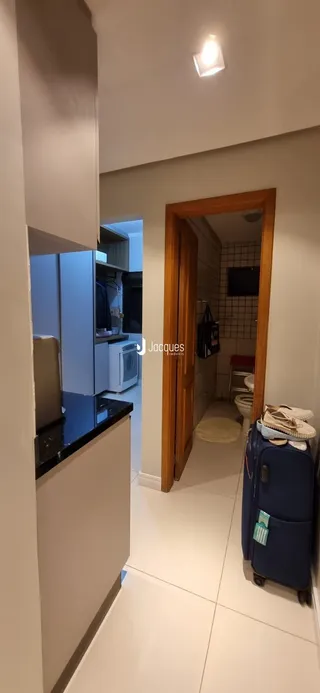 Vista de um corredor interno com porta de entrada para um banheiro.