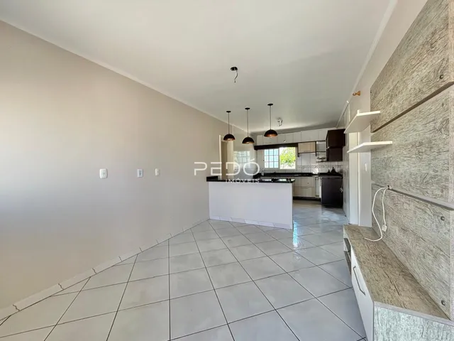 Ambiente de sala de estar e cozinha em um imóvel no Brasil.