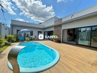 Foto da área externa com piscina e deck de madeira em uma residência.