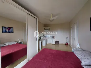 Quarto com cama e espelho refletindo o ambiente interno.