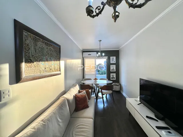 Sala de estar com sofá e mesa de jantar em um apartamento.