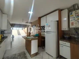 Hall de entrada com piso cerâmico e paredes claras de uma residência.
