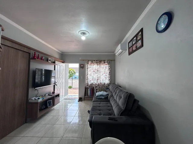 Sala de estar com sofá e televisão em um apartamento no Brasil.