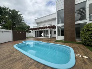Vista externa de uma casa com piscina e deck de madeira.