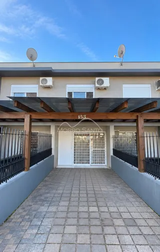 Fachada de uma residência com cobertura e grade de segurança em Lajeado.