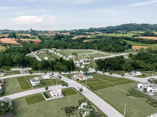 Vista aérea de um loteamento residencial com áreas verdes e construções no interior do Brasil.