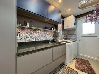 Foto de uma cozinha com armários superiores e revestimento de azulejos.