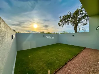 Vista externa de um jardim com gramado e muro em Lajeado.