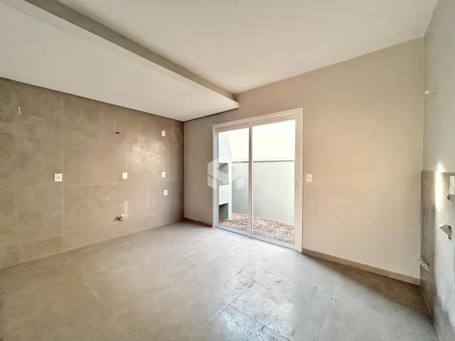 Interior de uma sala ampla com piso de concreto e porta de vidro.