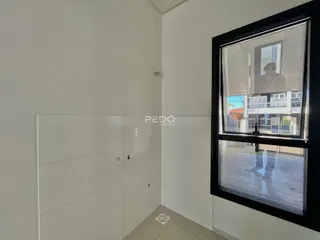Interior de um corredor com paredes brancas e piso claro.