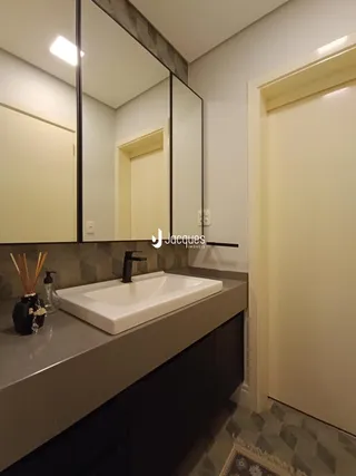 Foto de um banheiro com bancada e espelho em um imóvel.