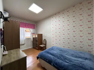 Foto de um quarto com cama e armário de madeira em uma residência.