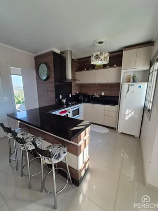 Cozinha moderna com ilha central e armários de madeira escura.