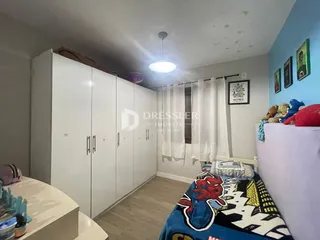 Quarto com guarda-roupas brancos e cama decorada em um imóvel em Lajeado.