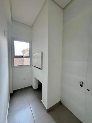Corredor interno com parede branca e janela.